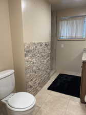 Bathroom featuring tile patterned flooring, toilet, and vanity