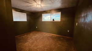 Spare room with a textured ceiling and carpet