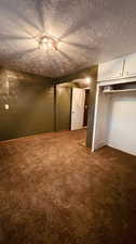 Unfurnished bedroom with ceiling fan, carpet, a textured ceiling, and a closet