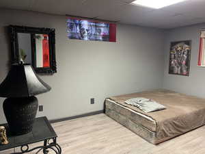 Bedroom with hardwood / wood-style flooring and a paneled ceiling