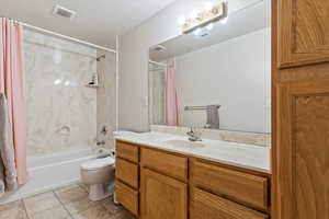 Full bathroom with tile patterned flooring, shower / bath combo, toilet, and vanity