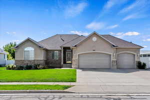 View of front of property featuring a garage and a front lawn