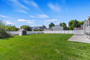 View of yard featuring a patio and a storage shed