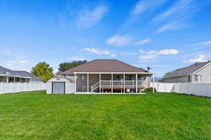 Back of house featuring a shed and a lawn