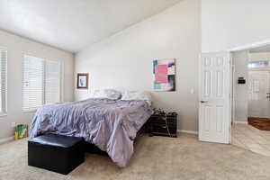 Carpeted bedroom featuring lofted ceiling