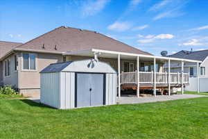 Back of house featuring a patio area, a shed, and a yard