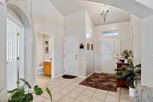 Tiled foyer with a high ceiling and a chandelier