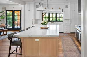 Kitchen with a wealth of natural light, backsplash, french doors, and white cabinets