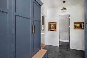 Mudroom featuring wood-type flooring and ornamental molding