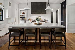 Kitchen featuring white cabinetry, backsplash, and hardwood / wood-style floors