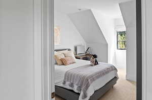 Carpeted bedroom featuring vaulted ceiling