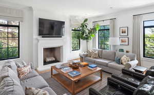 Living room with hardwood / wood-style flooring, crown molding, and a healthy amount of sunlight