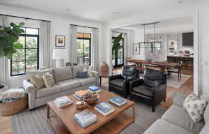 Living room with plenty of natural light, ornamental molding, and wood-type flooring