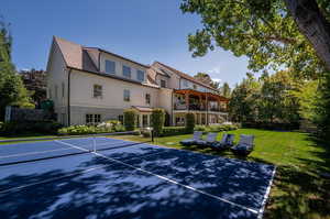 View of tennis court with a lawn