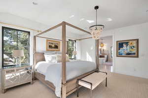 Primary bedroom Carpeted bedroom with connected bathroom and a chandelier