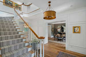 Stairway with hardwood / wood-style flooring and crown molding