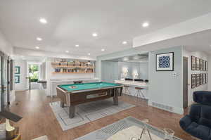 basement Playroom with light hardwood / wood-style floors and pool table