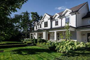 View of side of home featuring a lawn and mature landscaping