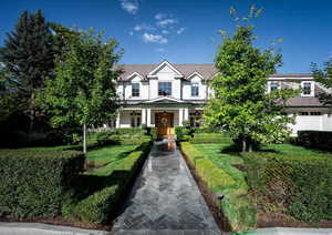 View of front of property featuring a front lawn and mature landscaping