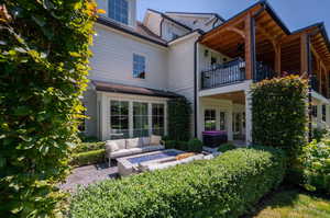 Back of property featuring a patio area, an outdoor hangout area, a balcony, and fire pit