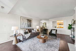 Living room with hardwood / wood-style flooring and crown molding