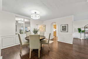 Dining room featuring a textured ceiling, crown molding, and wood-type flooring