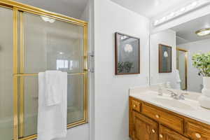 Bathroom featuring an enclosed shower and vanity