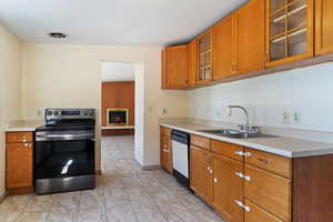 Kitchen featuring sink, stainless steel electric range, white dishwasher, and light tile patterned floors