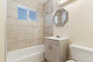 Full bathroom featuring toilet, tiled shower / bath, and vanity