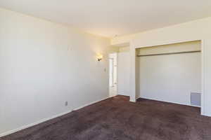 Unfurnished bedroom featuring a closet and carpet flooring