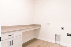 Clothes washing area featuring cabinets, light hardwood / wood-style floors, hookup for a washing machine, and electric dryer hookup