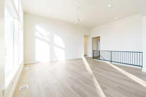 Unfurnished room with ceiling fan and light hardwood / wood-style flooring