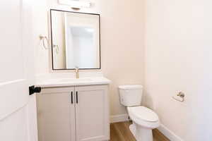 Bathroom featuring vanity, hardwood / wood-style floors, and toilet