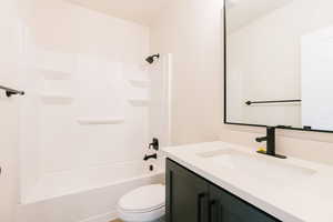 Full bathroom featuring vanity, shower / bathtub combination, and toilet