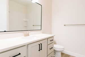 Bathroom featuring wood-type flooring, vanity, and toilet