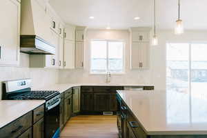 Kitchen with pendant lighting, sink, white cabinetry, dark brown cabinets, and stainless steel appliances