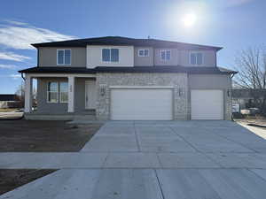 View of front facade featuring a porch and a garage