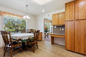 Dining area with light hardwood / wood-style flooring and a chandelier