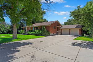 Ranch-style home featuring a garage and a front lawn