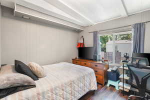 Bedroom # 4 with dark hardwood / wood-style flooring and beamed ceiling