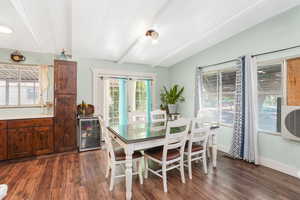 Dining area with beam ceiling, wine cooler, and dark wood-type flooring