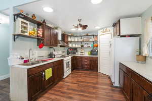 Kitchen with sink, white appliances, ceiling fan, and dark hardwood / wood-style floors