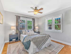 Bedroom with light hardwood / wood-style floors and ceiling fan