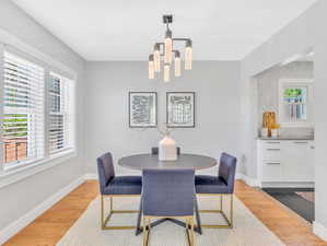 Dining room featuring light wood-type flooring and a notable chandelier