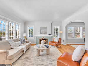 Living room with light hardwood / wood-style floors and a tiled fireplace