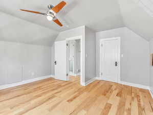 2nd floor bedroom with ceiling fan, light wood-type flooring, and lofted ceiling