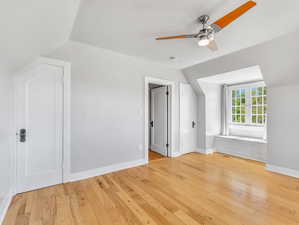 2nd floor bedroom with ceiling fan, light wood-type flooring, and lofted ceiling