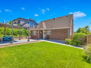 Back of property featuring a pergola, a yard, and a patio