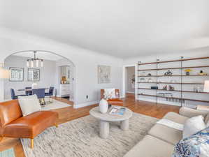 Living room with a notable chandelier and light hardwood / wood-style floors