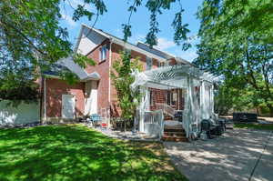 Back of house with a lawn, a pergola, a patio area, and a deck